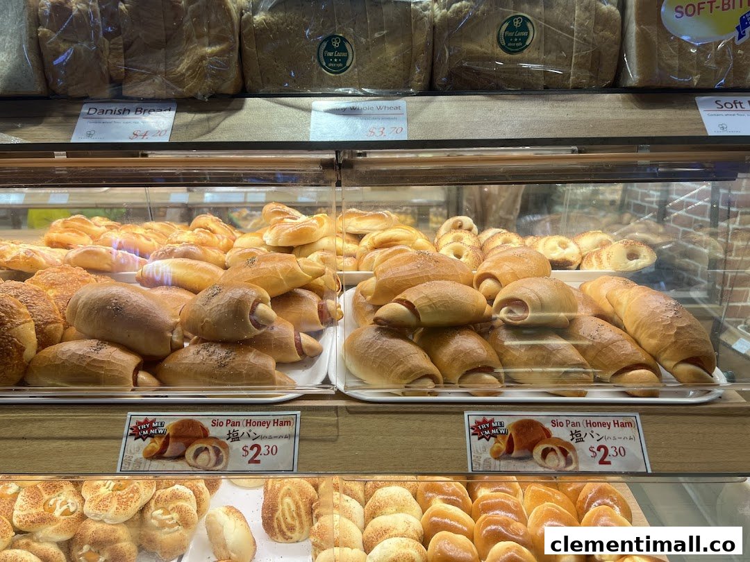 A vibrant display case showcasing a variety of freshly baked breads and pastries at Four Leaves bakery.