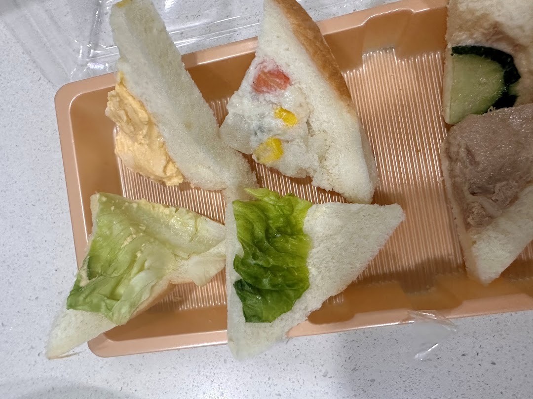 A tray of assorted sandwiches, including egg salad, vegetable, lettuce, and tuna fillings.