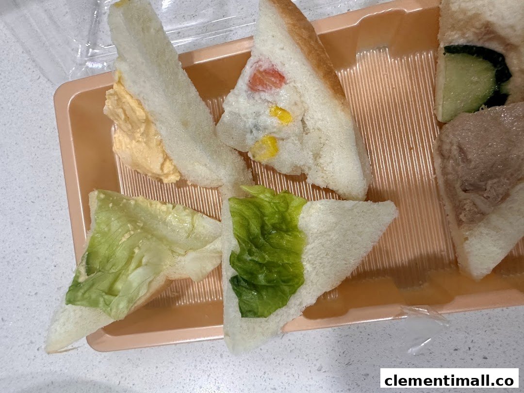 A tray of assorted sandwiches, including egg salad, vegetable, lettuce, and tuna fillings.