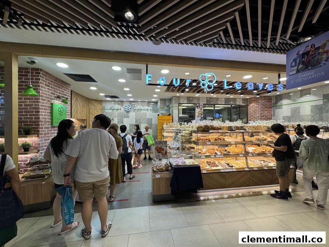 Customers queue at the entrance of Four Leaves bakery, showcasing a wide selection of freshly baked goods.