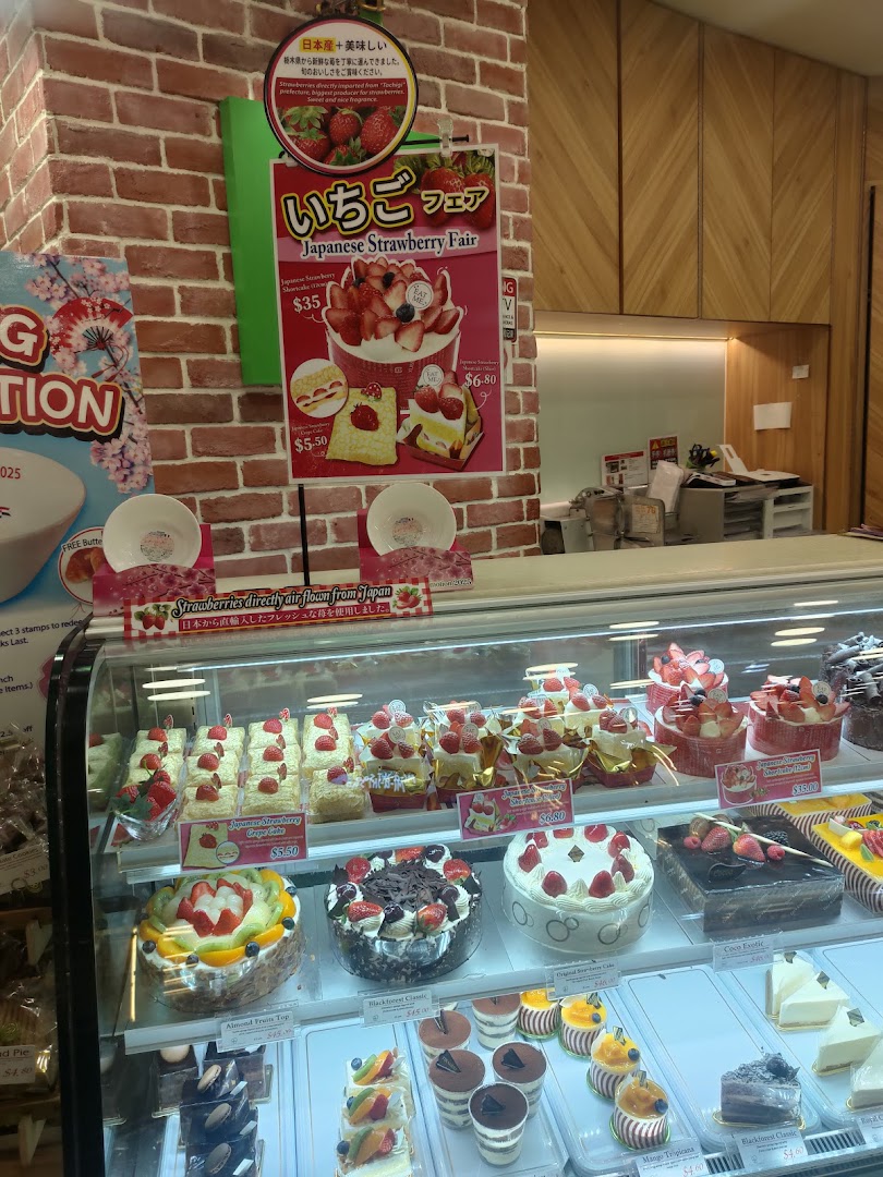 A vibrant display of fresh cakes and pastries, featuring a Japanese Strawberry Fair promotion.