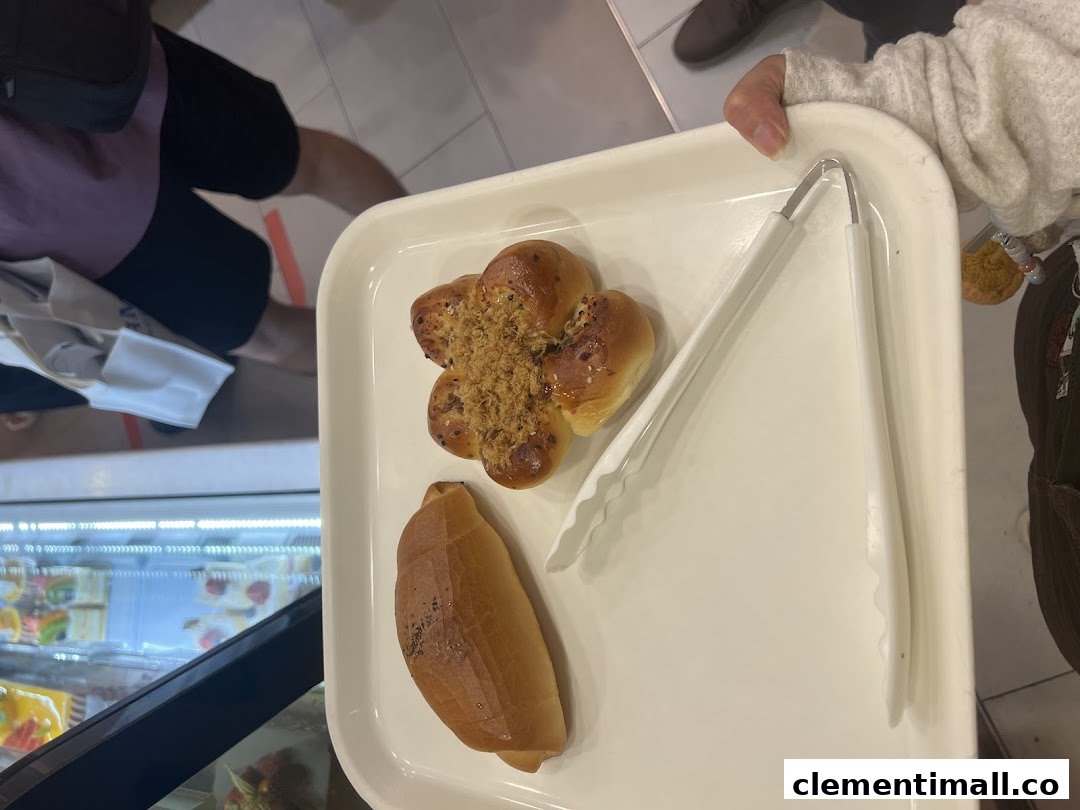 A customer holds a tray with freshly baked buns and tongs from Four Leaves bakery.