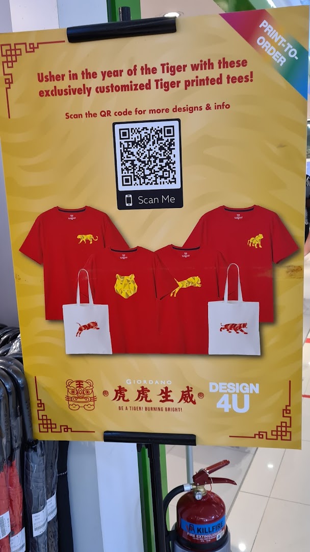 A promotional standee for Giordano showcasing red Tiger-themed t-shirts and tote bags for the Year of the Tiger.