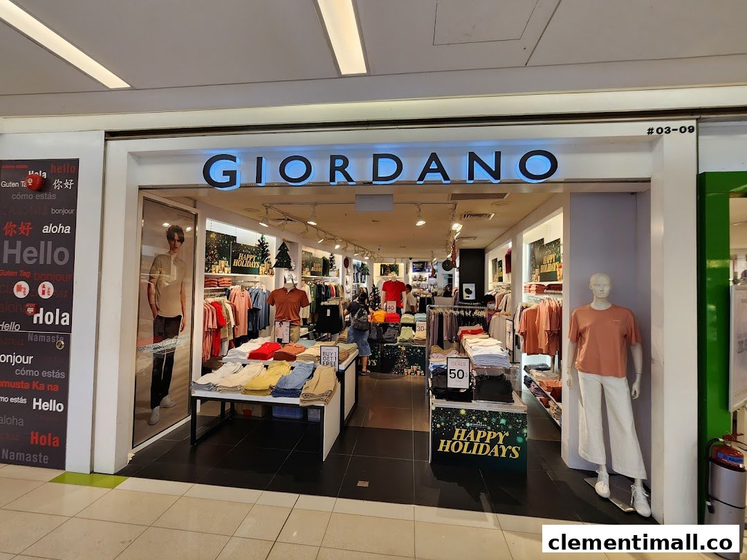 The brightly lit entrance of a Giordano clothing store, featuring mannequins, displays, and holiday decorations.