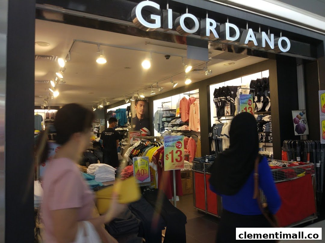 The entrance of a Giordano clothing store, showcasing apparel displays and customers inside.