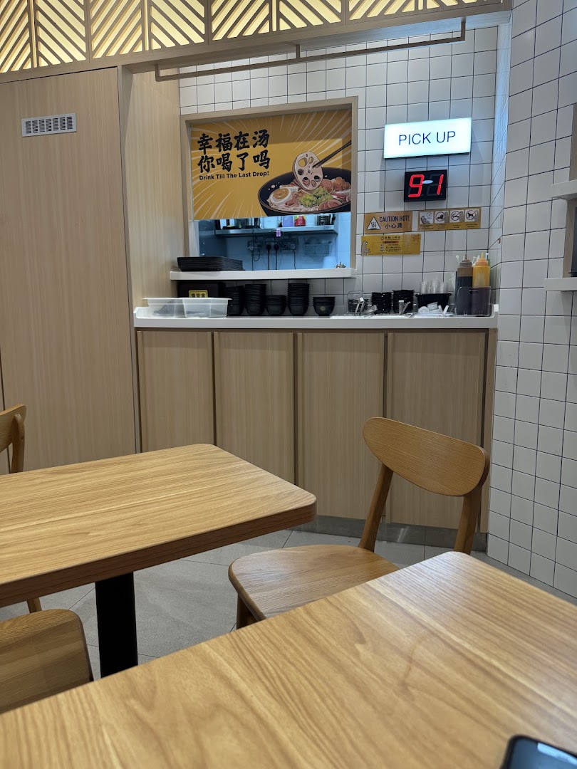 Interior view of Gong Yuan Ma La Tang showing dining area, pick-up counter, and promotional poster.