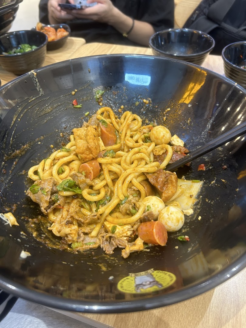 A close-up of a delicious, spicy Mala Tang bowl with noodles, meat, and various ingredients.