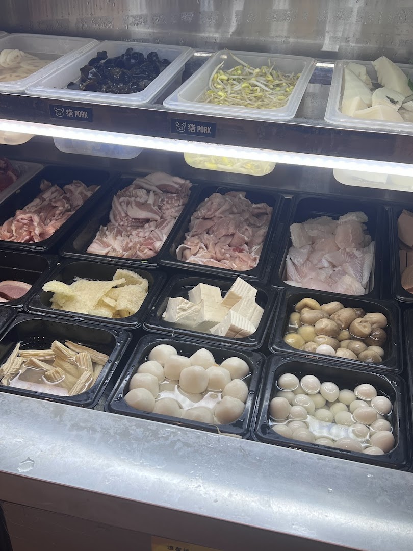 A vibrant display of fresh ingredients for custom mala tang, including meats, vegetables, and various balls.