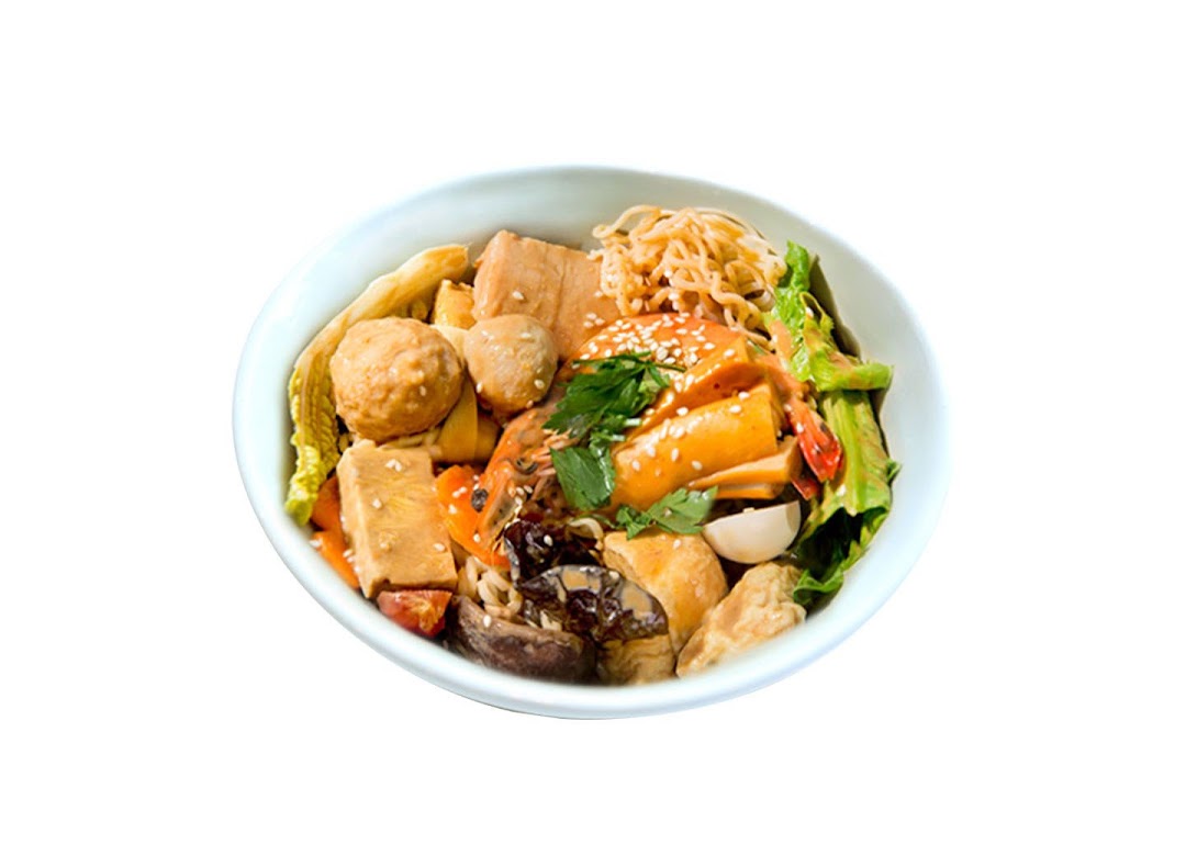 A vibrant bowl of Mala Tang featuring noodles, meatballs, and assorted ingredients.
