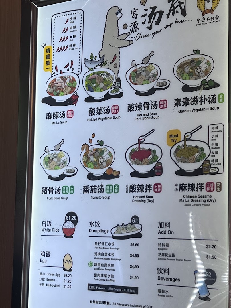 A brightly lit menu board for Gong Yuan Ma La Tang, showcasing various soup bases, side dishes, and beverages.