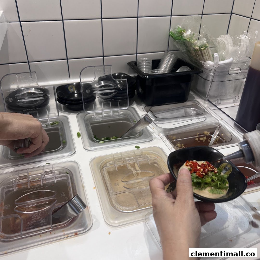A customer customizes their sauce at a self-service condiment station with various toppings.