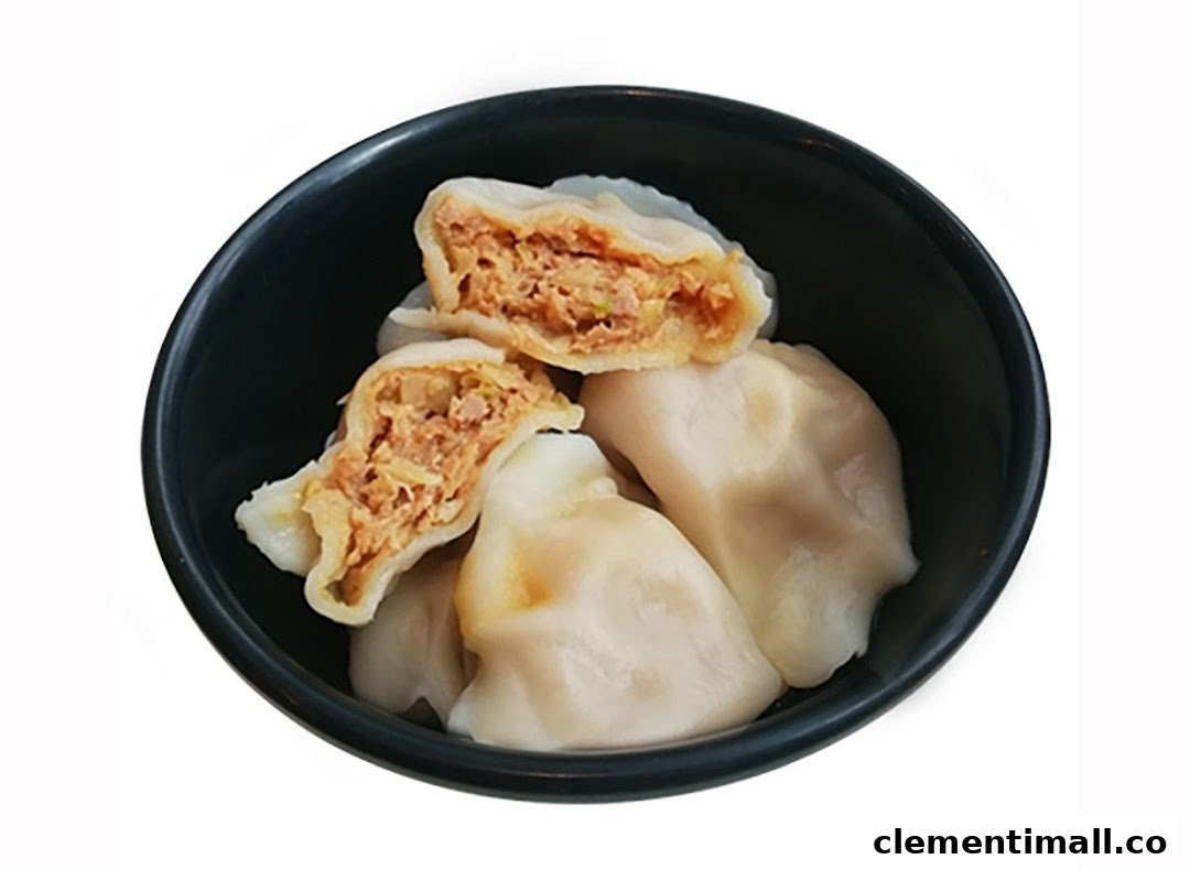 A bowl of savory dumplings, with one cut open to reveal the delicious filling.