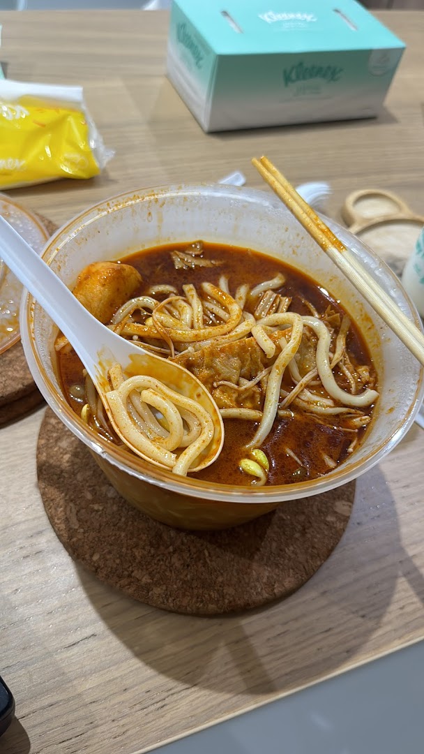 A close-up of a vibrant bowl of spicy Mala Tang noodle soup with various ingredients.