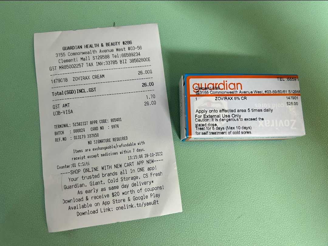 A Guardian Health & Beauty receipt and a Zovirax Cream product box are displayed on a green surface.