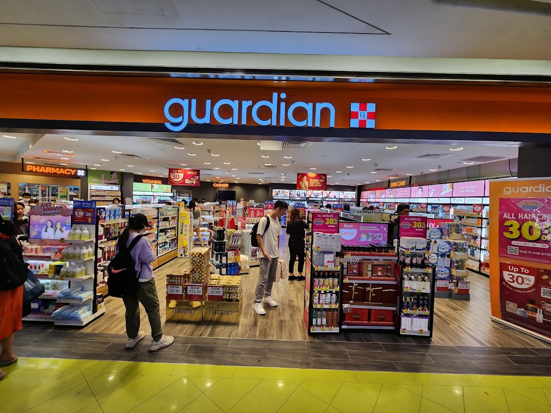 The entrance of a Guardian Health & Beauty pharmacy, showcasing various health and beauty products.