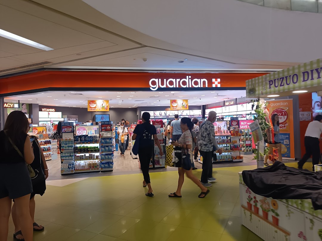 The entrance of Guardian Health & Beauty Pharmacy with customers browsing products.
