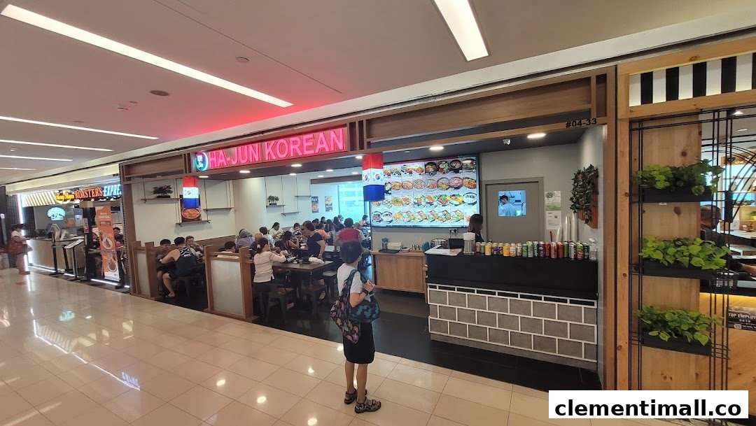 Ha-Jun Korean restaurant's bustling entrance, showcasing diners and a vibrant digital menu board.
