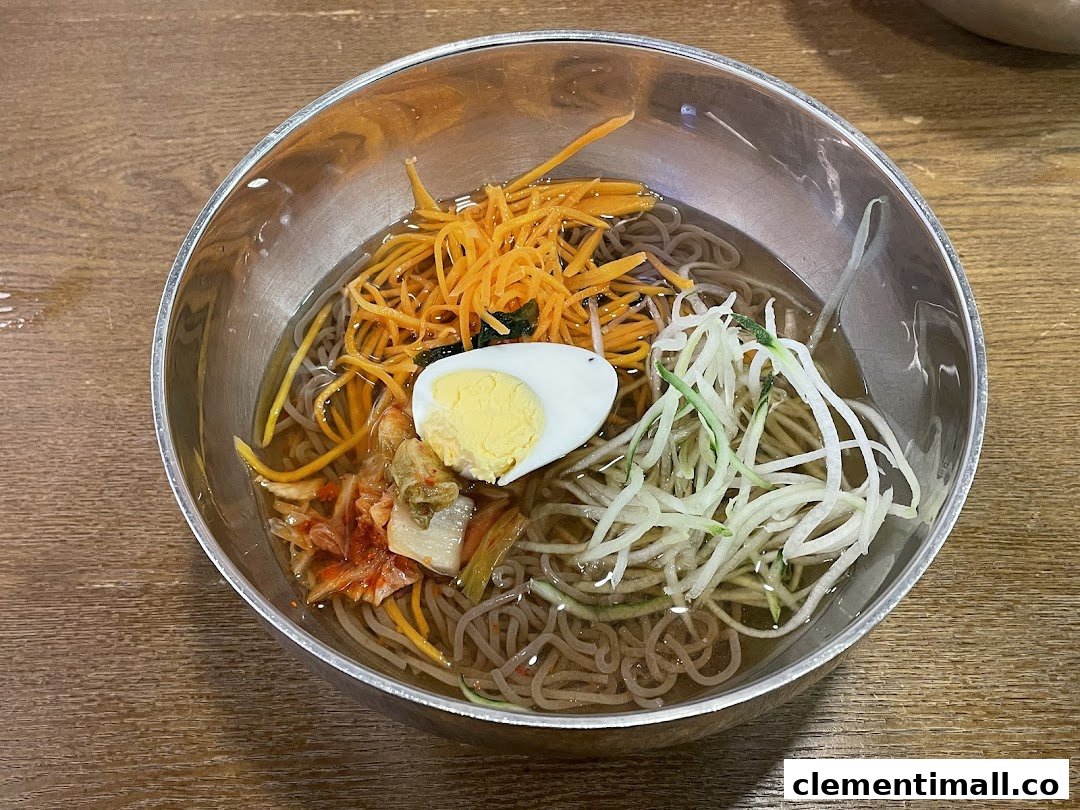 A refreshing bowl of Korean cold noodles (Naengmyeon) with egg, kimchi, and fresh vegetables.