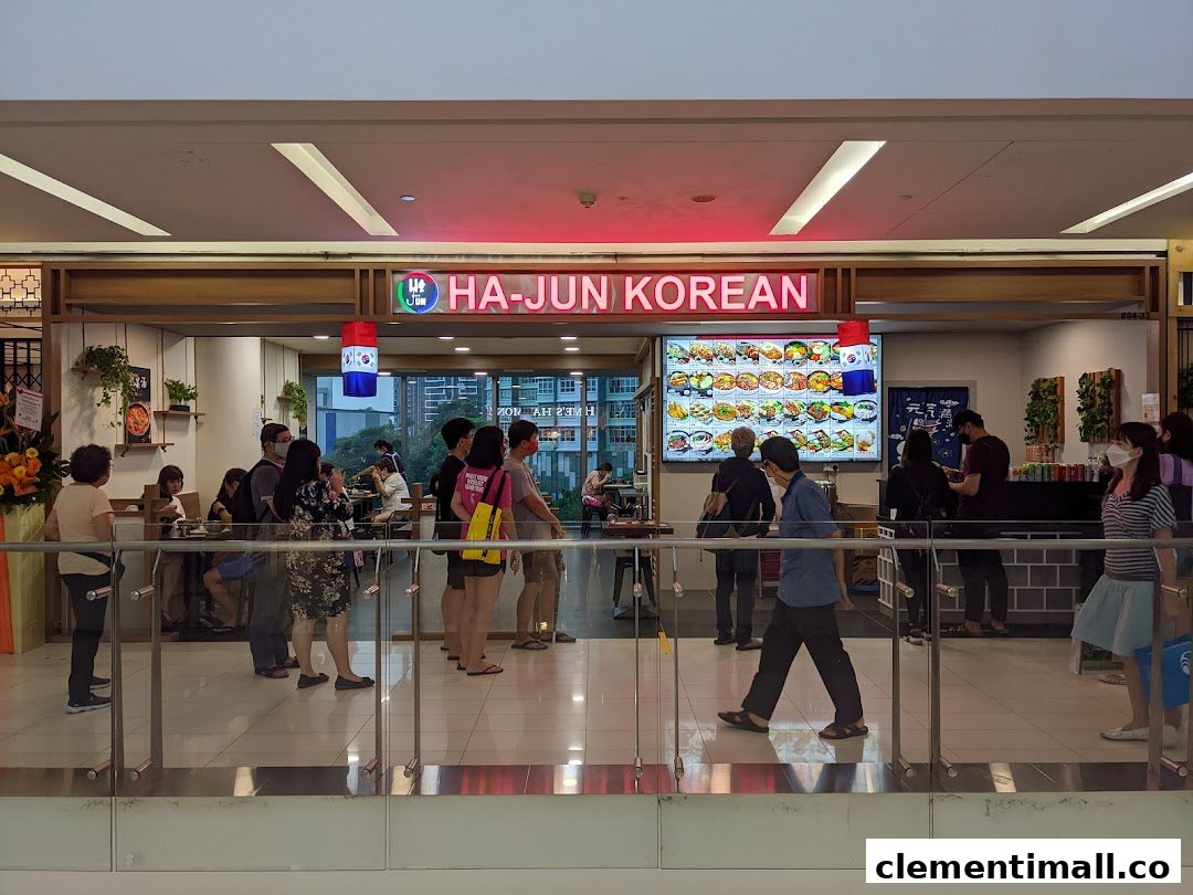 The bustling entrance of Ha-Jun Korean restaurant, featuring its signage, customers, and a digital menu board.