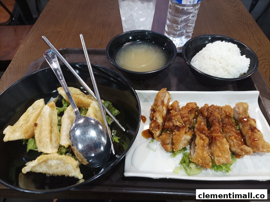 A delicious Korean meal featuring crispy fried chicken, dumplings, rice, and soup on a tray.