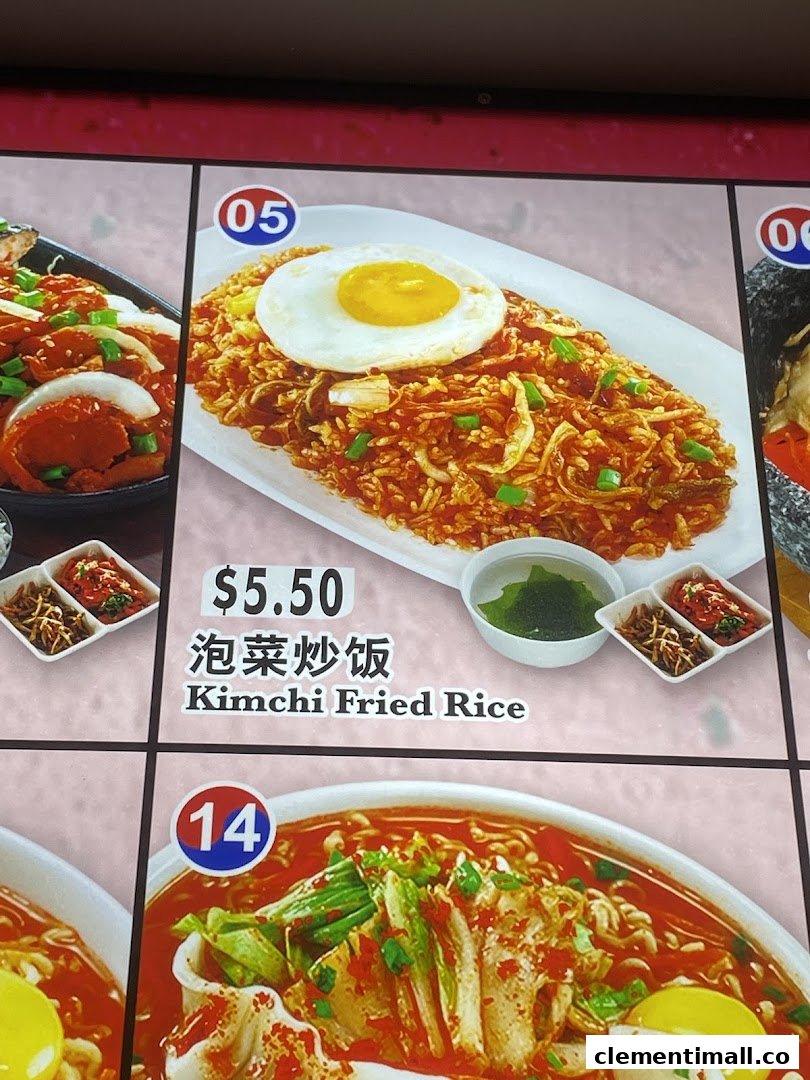 A menu display showing a vibrant plate of Kimchi Fried Rice with a fried egg and side dishes.