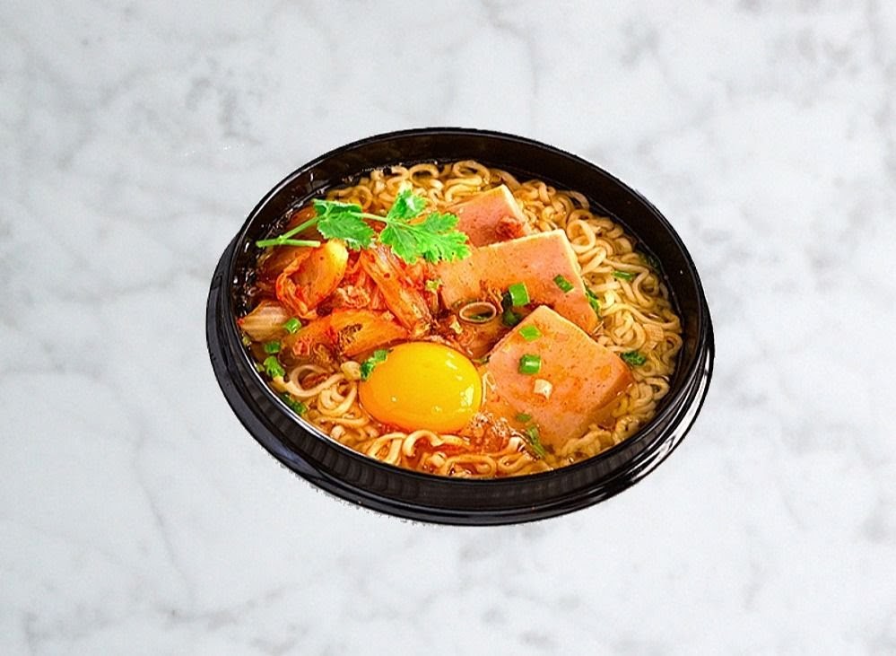 A vibrant bowl of Korean ramen with kimchi, spam, a raw egg yolk, and fresh herbs.