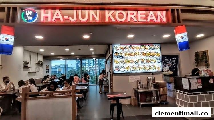 The interior of Ha-Jun Korean restaurant, featuring a vibrant menu display and diners enjoying their meals.