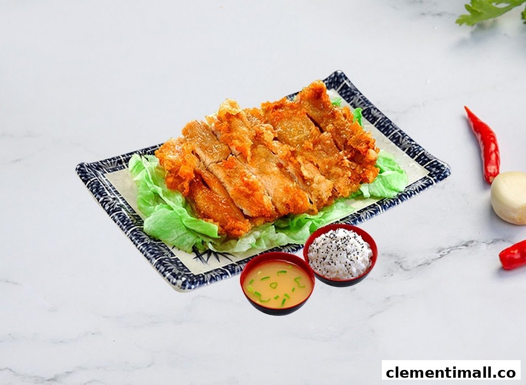 A plate of golden fried chicken with fresh lettuce, served with rice and miso soup.