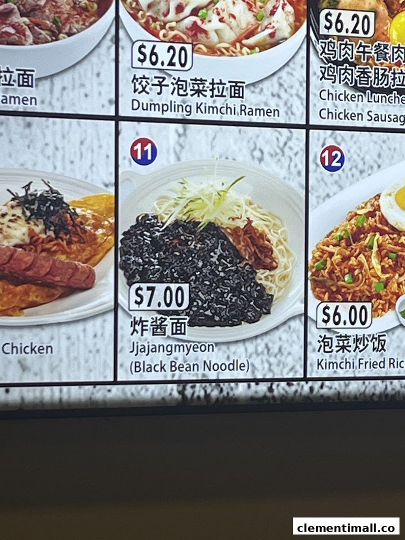 A close-up of a digital menu board displaying various Korean noodle and rice dishes with prices.