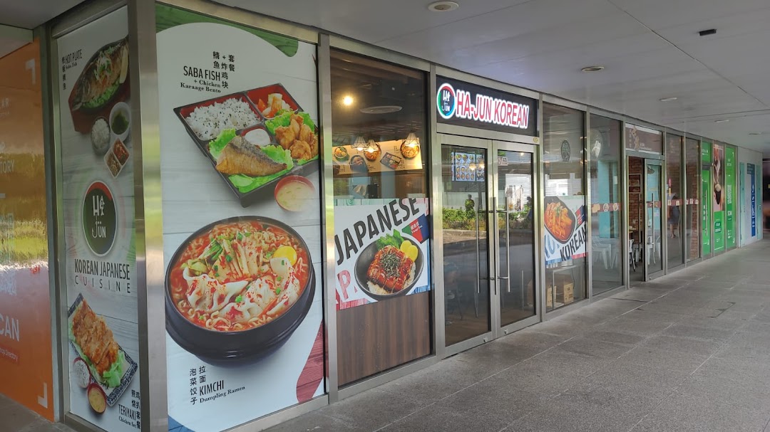 The shopfront of Ha-Jun Korean, featuring large window decals showcasing various Korean and Japanese dishes.