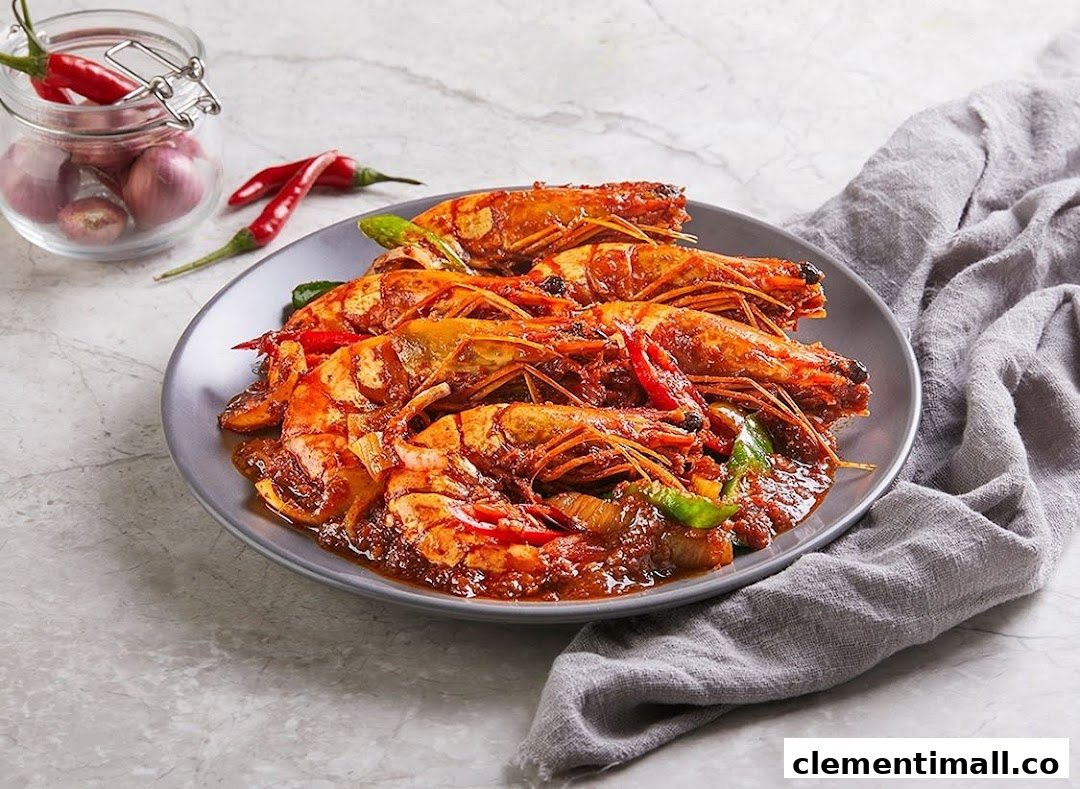 A plate of large, spicy prawns in a rich red sauce, garnished with chili and bell peppers.