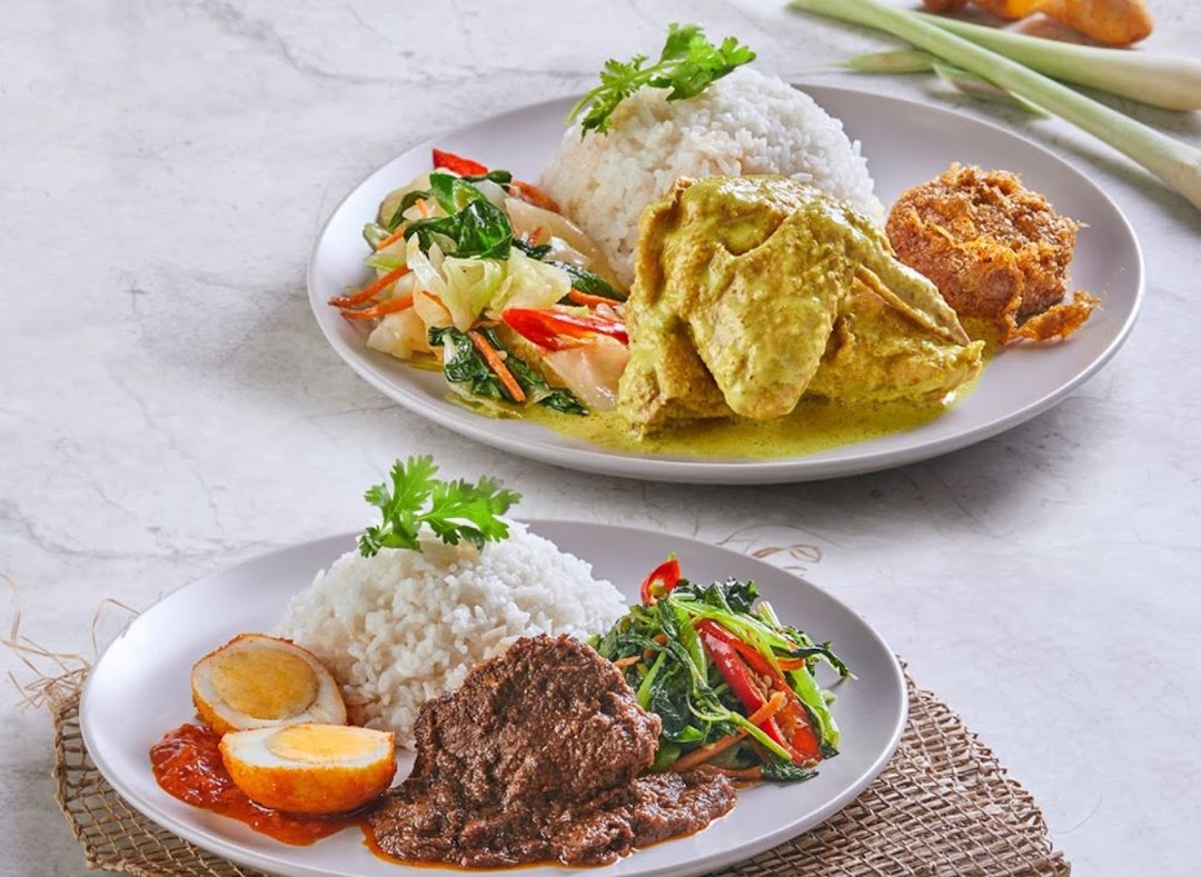 Two plates of traditional Malay/Indonesian dishes featuring rice, chicken, beef rendang, vegetables, and eggs.