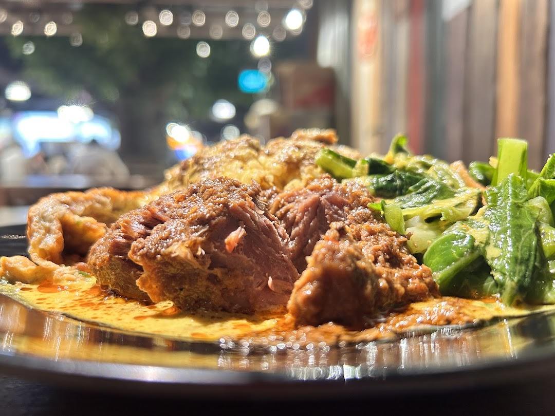 A close-up of a delicious Malay dish featuring tender meat, vegetables, and rich sauce.