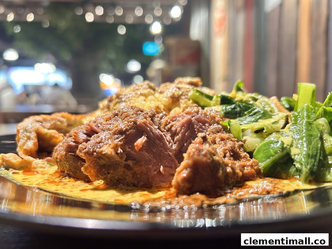 A close-up of a delicious Malay dish featuring tender meat, vegetables, and rich sauce.