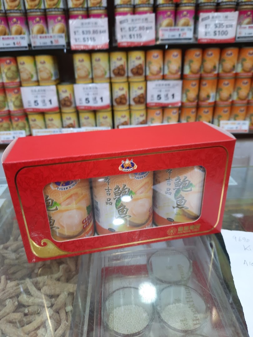 A red gift box of canned abalone displayed in Hockhua Tonic with shelves of various products in the background.