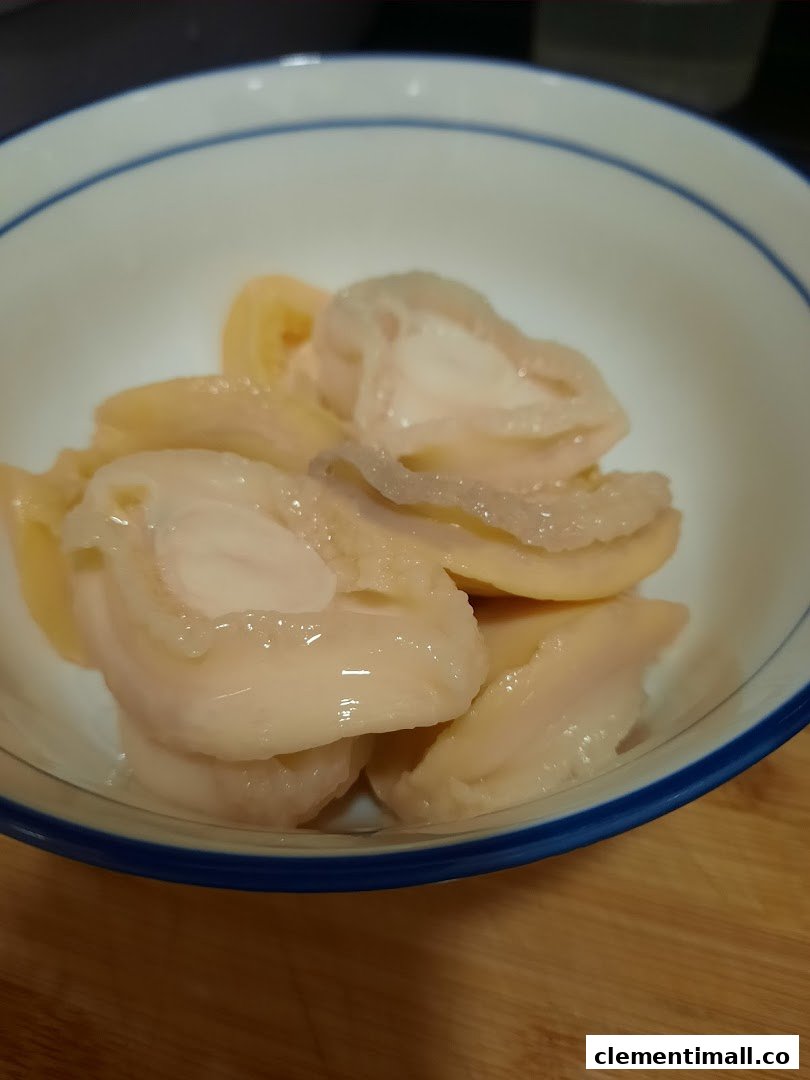 A close-up of tender, sliced abalone or similar tonic ingredients in a white bowl.