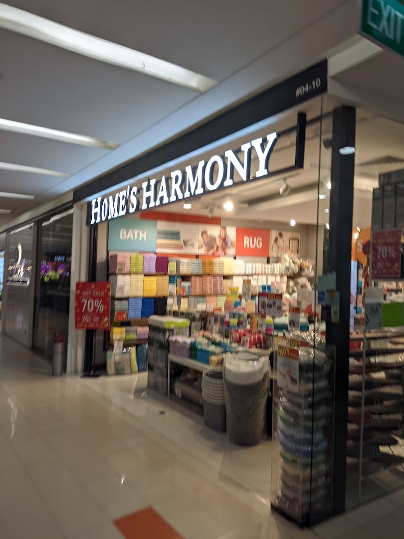 The brightly lit storefront of Home's Harmony, showcasing home essentials and textiles.
