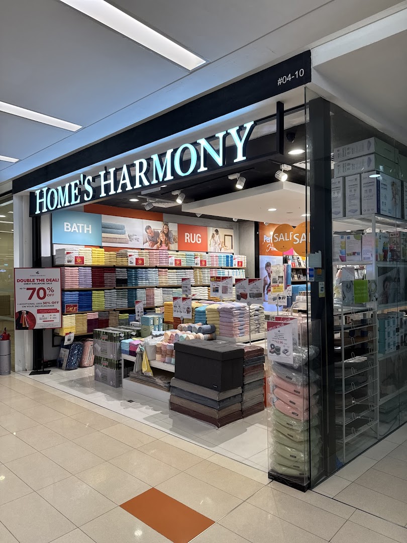 The storefront of Home's Harmony, showcasing home textiles, bath, and rug products.