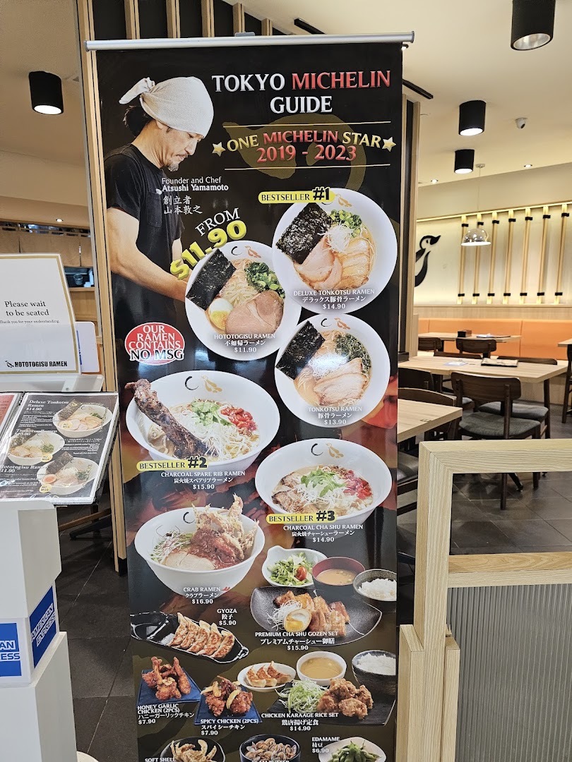 A large menu standee for Hototogisu Ramen, showcasing various ramen dishes, sides, and Michelin star recognition.