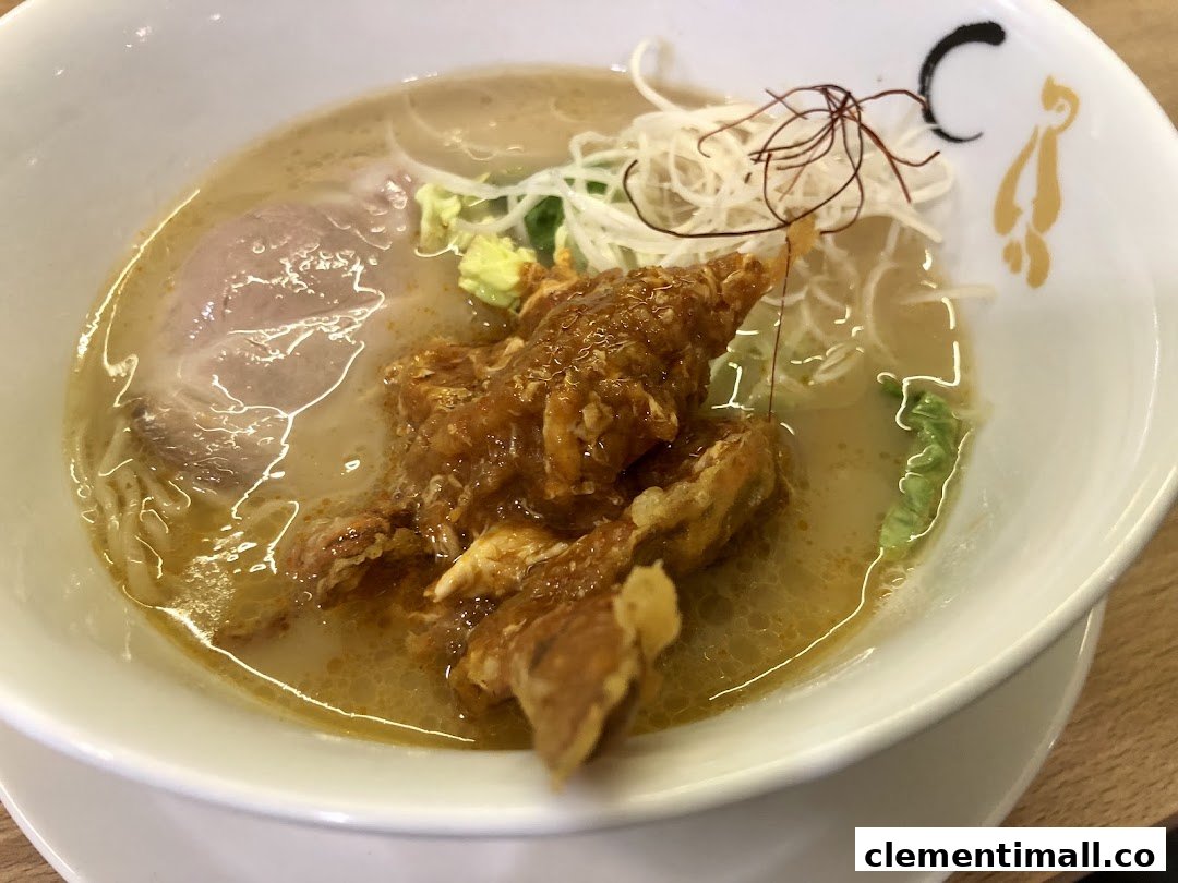 A close-up of a delicious ramen bowl featuring rich broth, noodles, pork chashu, and crispy fried chicken.