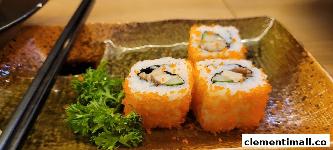 Three vibrant sushi rolls with orange roe and green garnish on a textured plate, with chopsticks.
