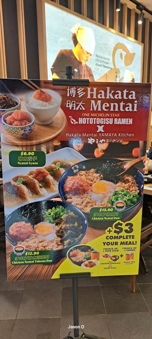 A promotional stand showcasing ramen and donburi dishes with prices and a meal upgrade offer.