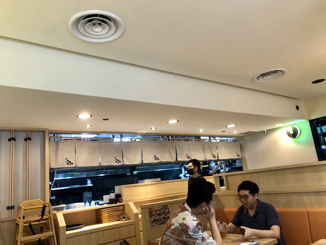 Interior view of Hototogisu Ramen, showing customers dining and the open kitchen area.