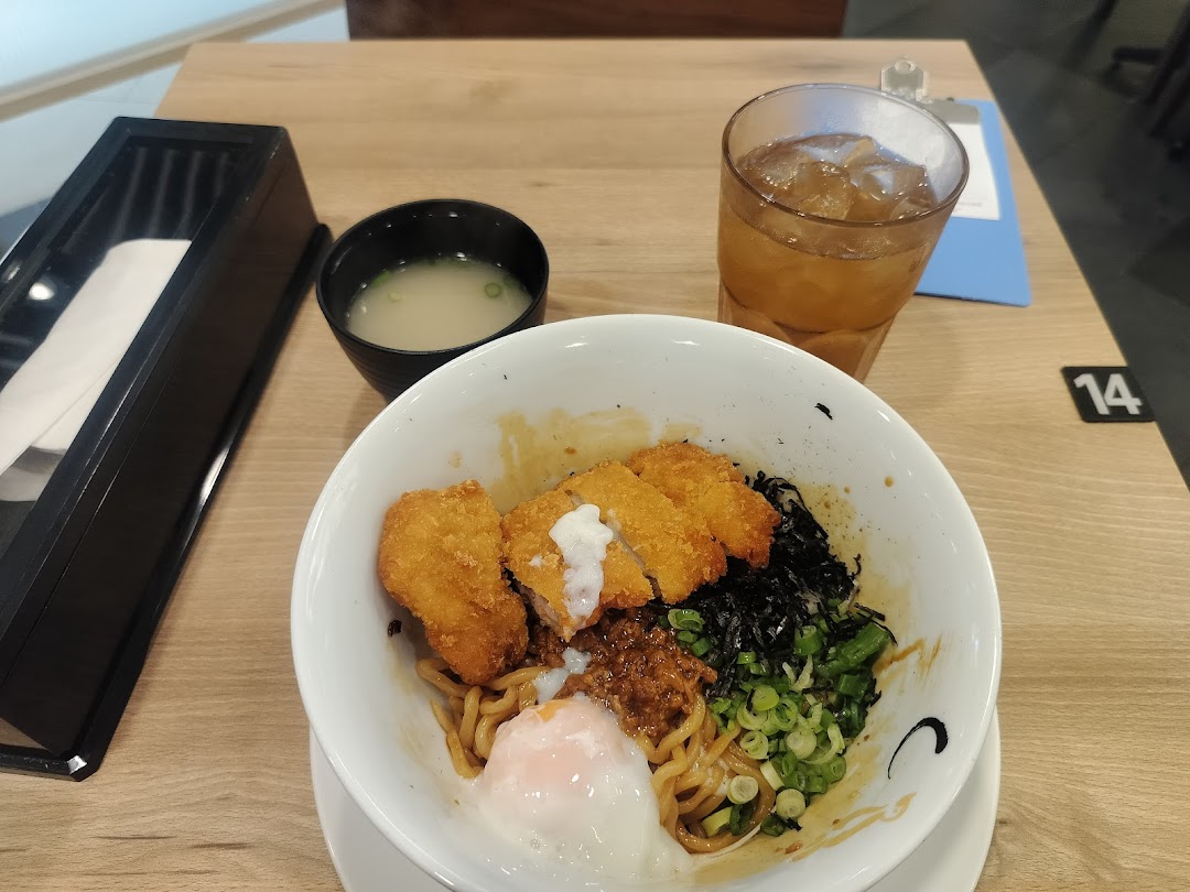 A delicious bowl of ramen with crispy chicken katsu, a poached egg, and various toppings.