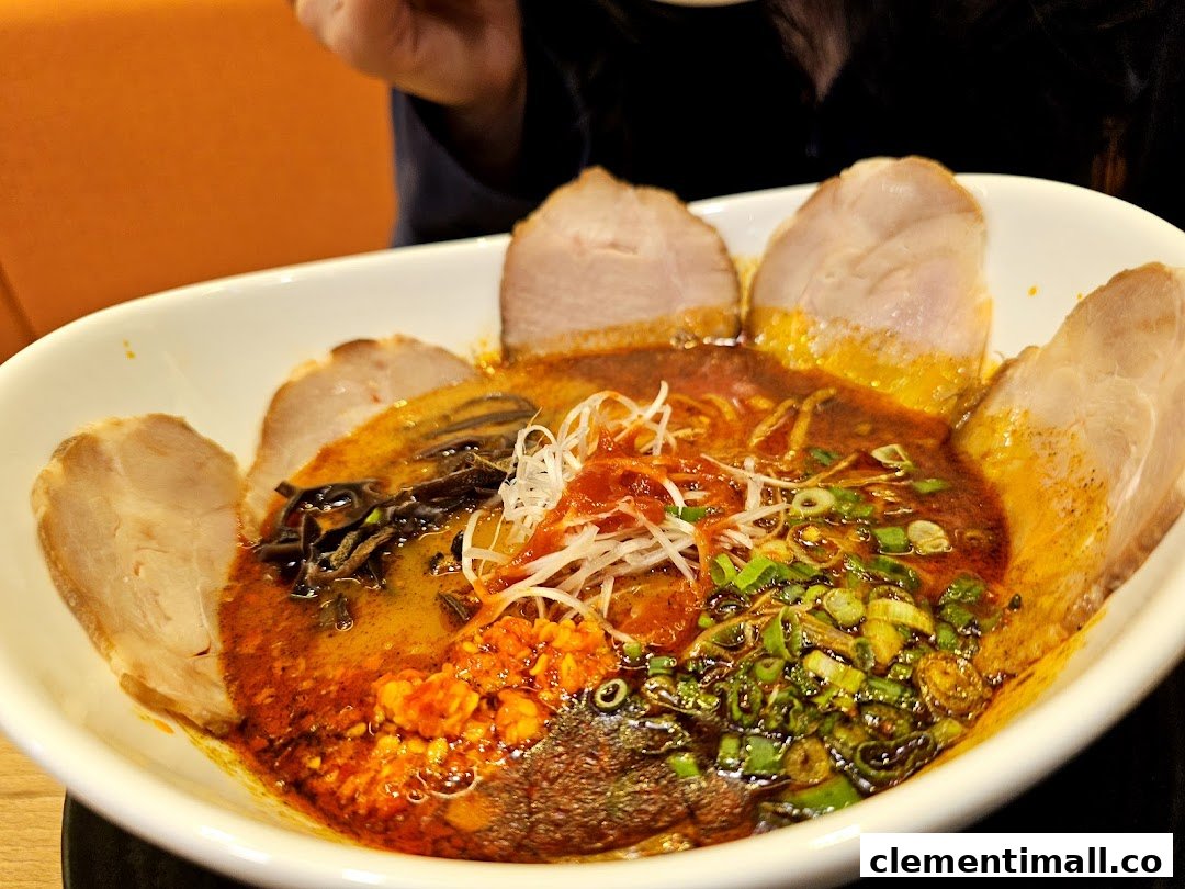 A close-up of a vibrant bowl of ramen with rich broth, chashu, and various toppings.