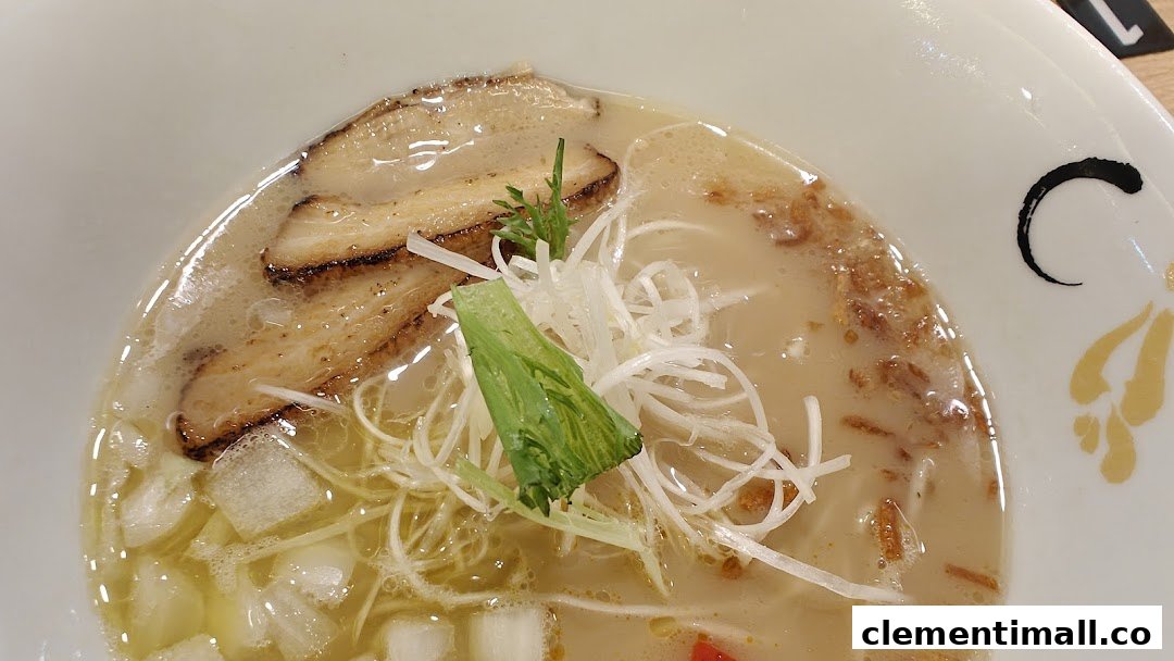 A close-up of a delicious bowl of ramen with pork slices, green onions, and other toppings.