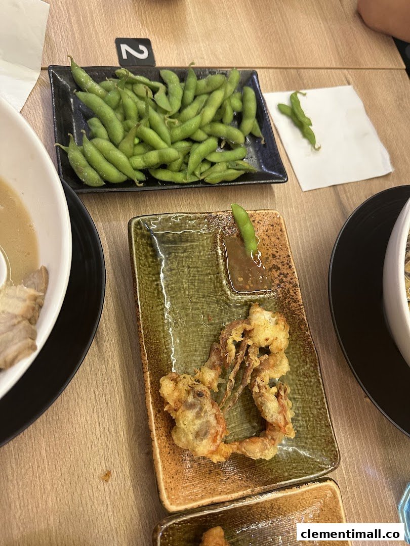 Close-up of delicious edamame and crispy soft-shell crab tempura served on a wooden table.