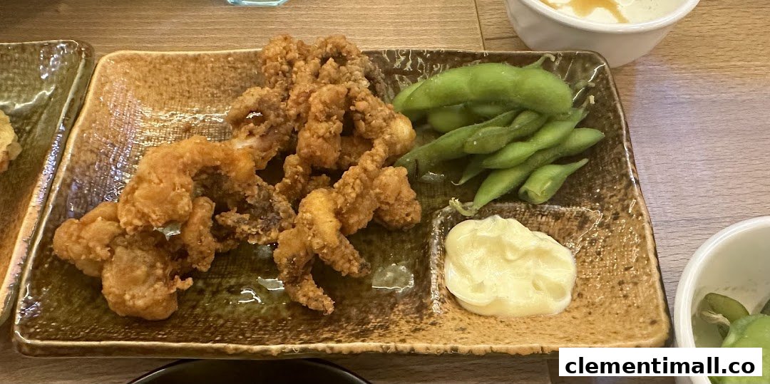 A plate of crispy fried calamari, fresh edamame, and creamy mayonnaise, served on a rustic dish.