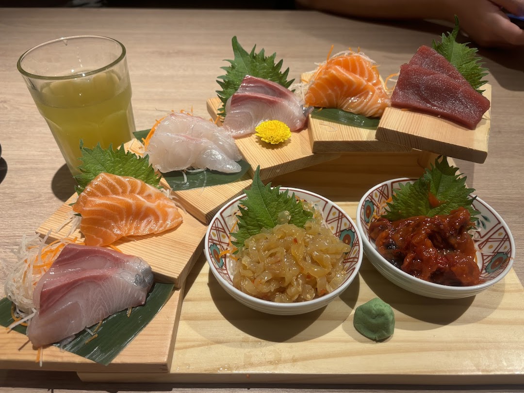 A beautifully arranged platter of fresh sashimi, side dishes, and a drink at Ichiban Boshi.