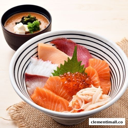 A vibrant bowl of assorted sashimi donburi featuring fresh seafood and a side of miso soup.